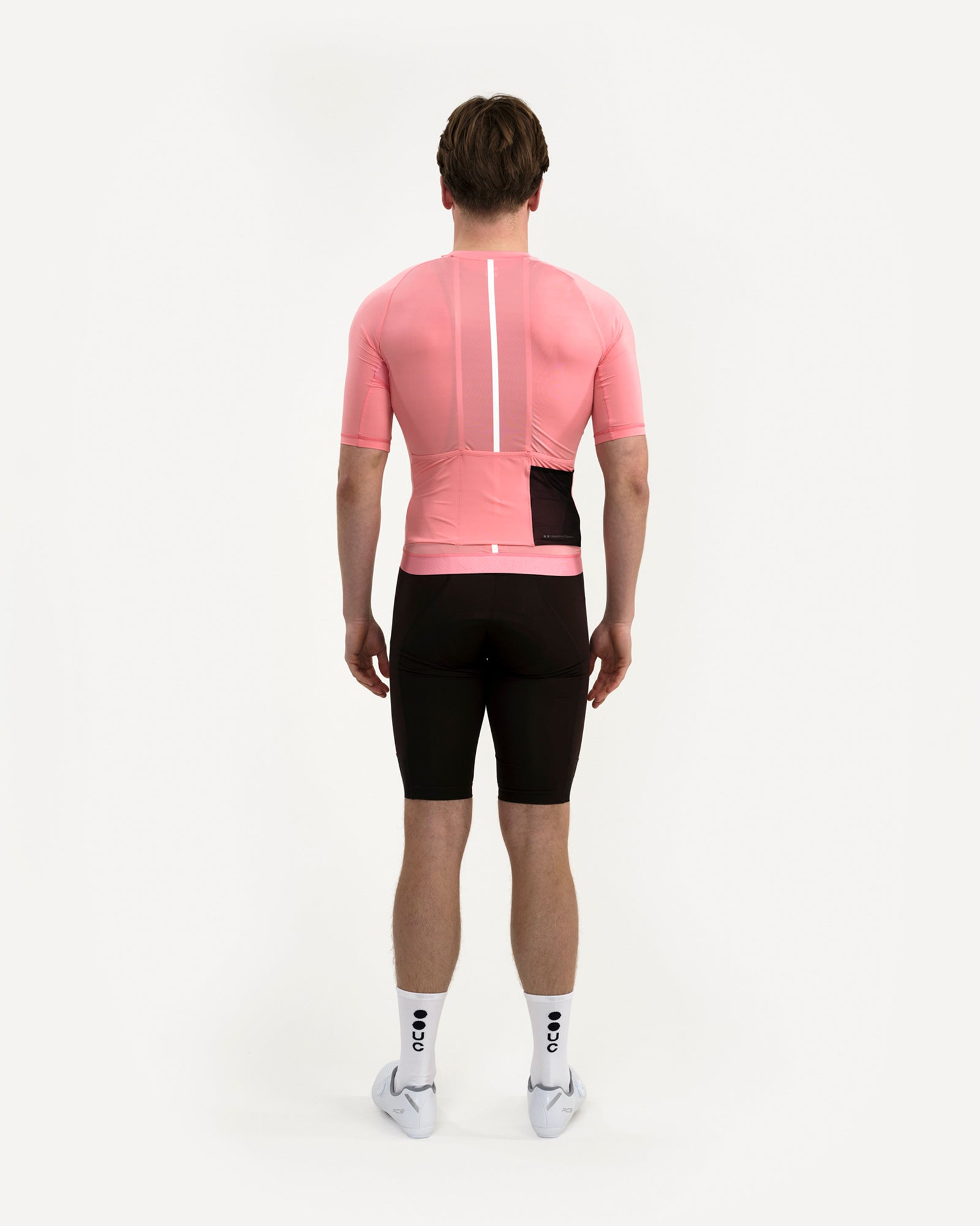 Back view of the Men's Mono Short Sleeve Jersey in Pink on model, with centre-back reflective stripe and side stash pocket.