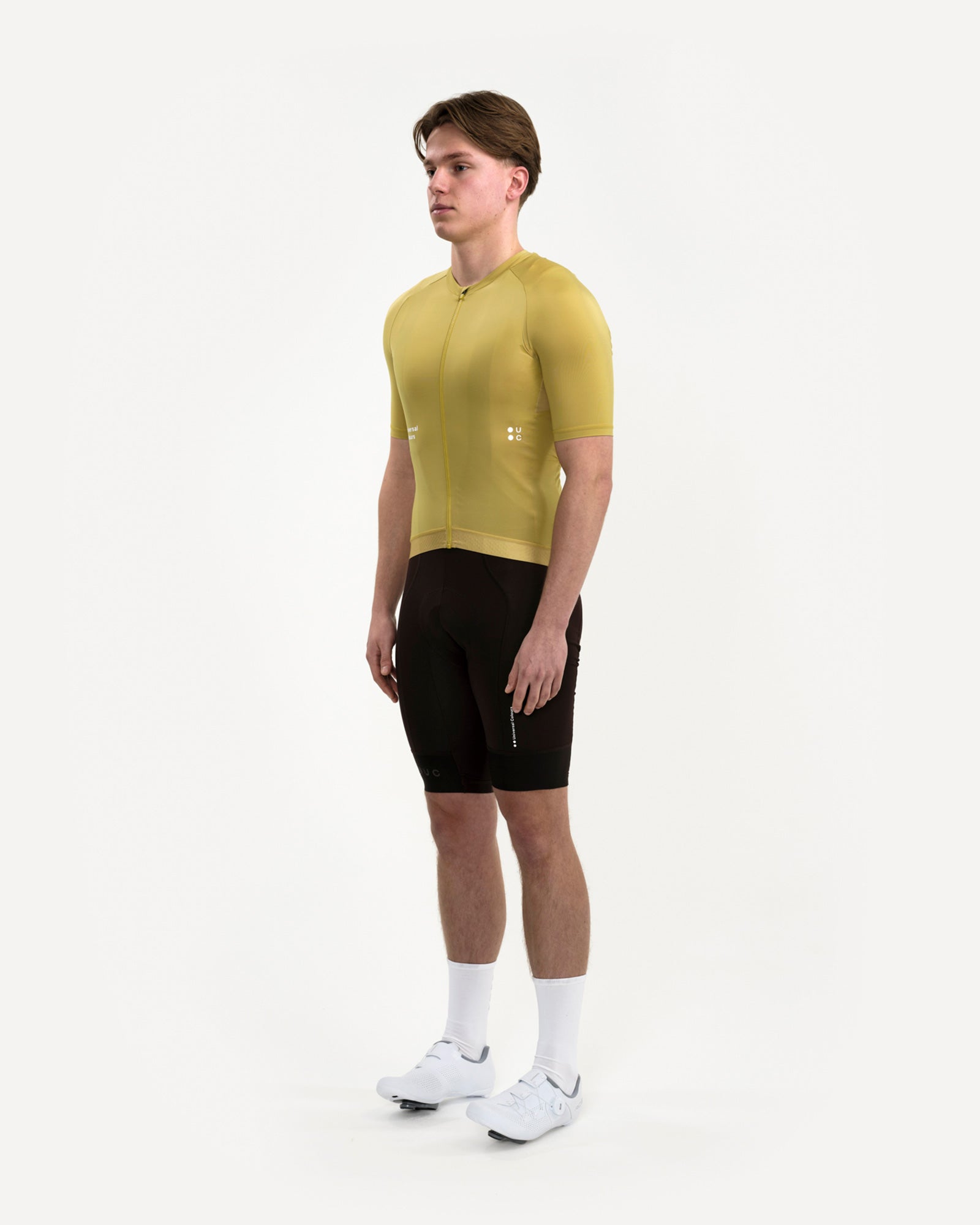 Model in the Men's Mono Short Sleeve Jersey in Acidic Yellow, three-quarter view, paired with black UC bib shorts.