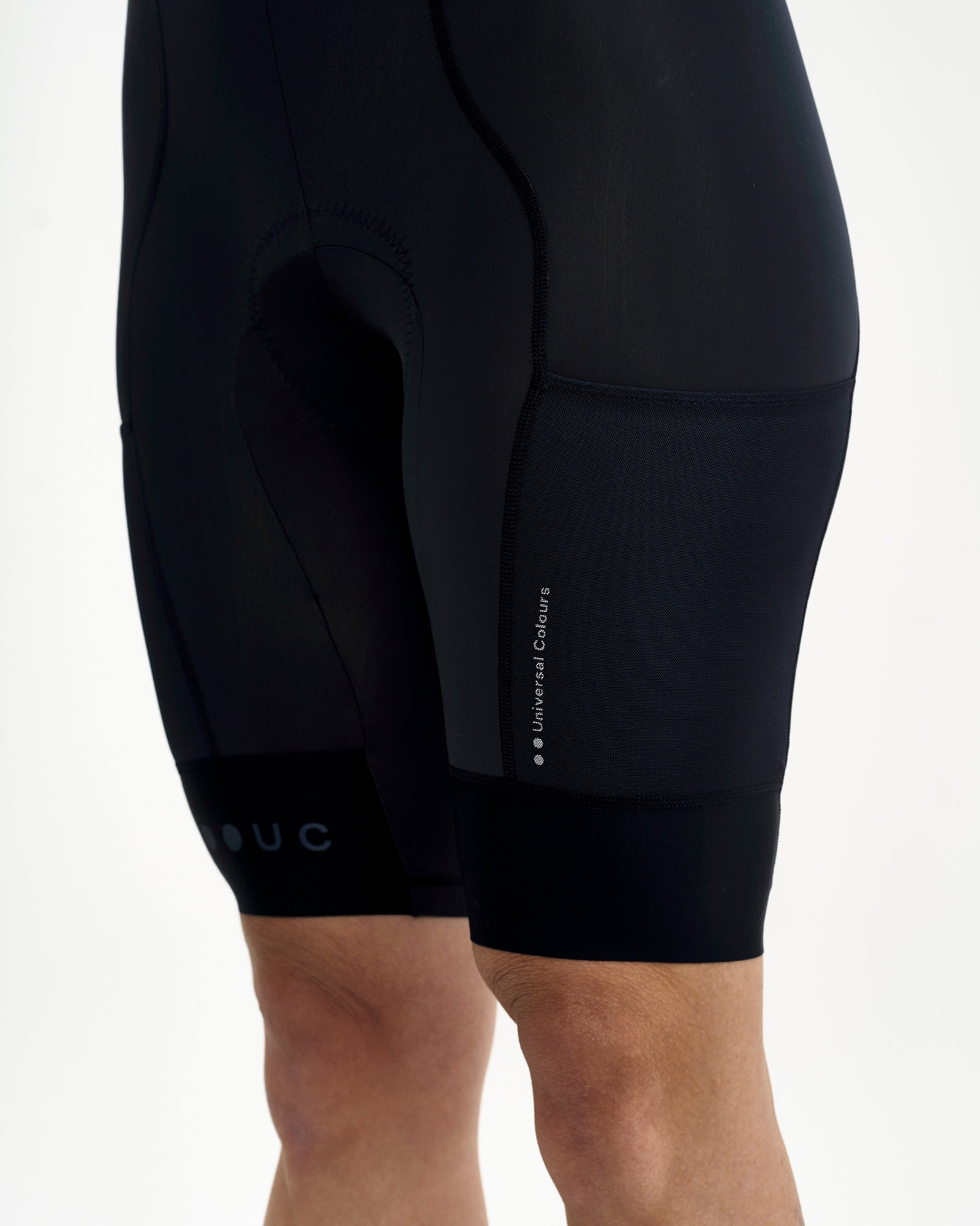 Side detail: mesh cargo pocket with tonal Universal Colours wordmark on the Women's Mono Cargo Bib Short, Navy Blue.