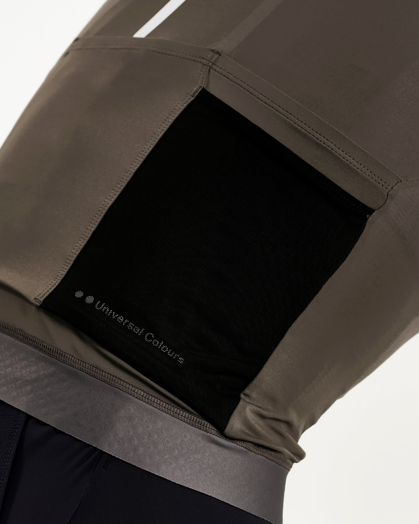 Rear pocket close-up: black mesh-lined cargo pocket on the Women's Mono Jersey, with tonal Universal Colours wordmark inside.