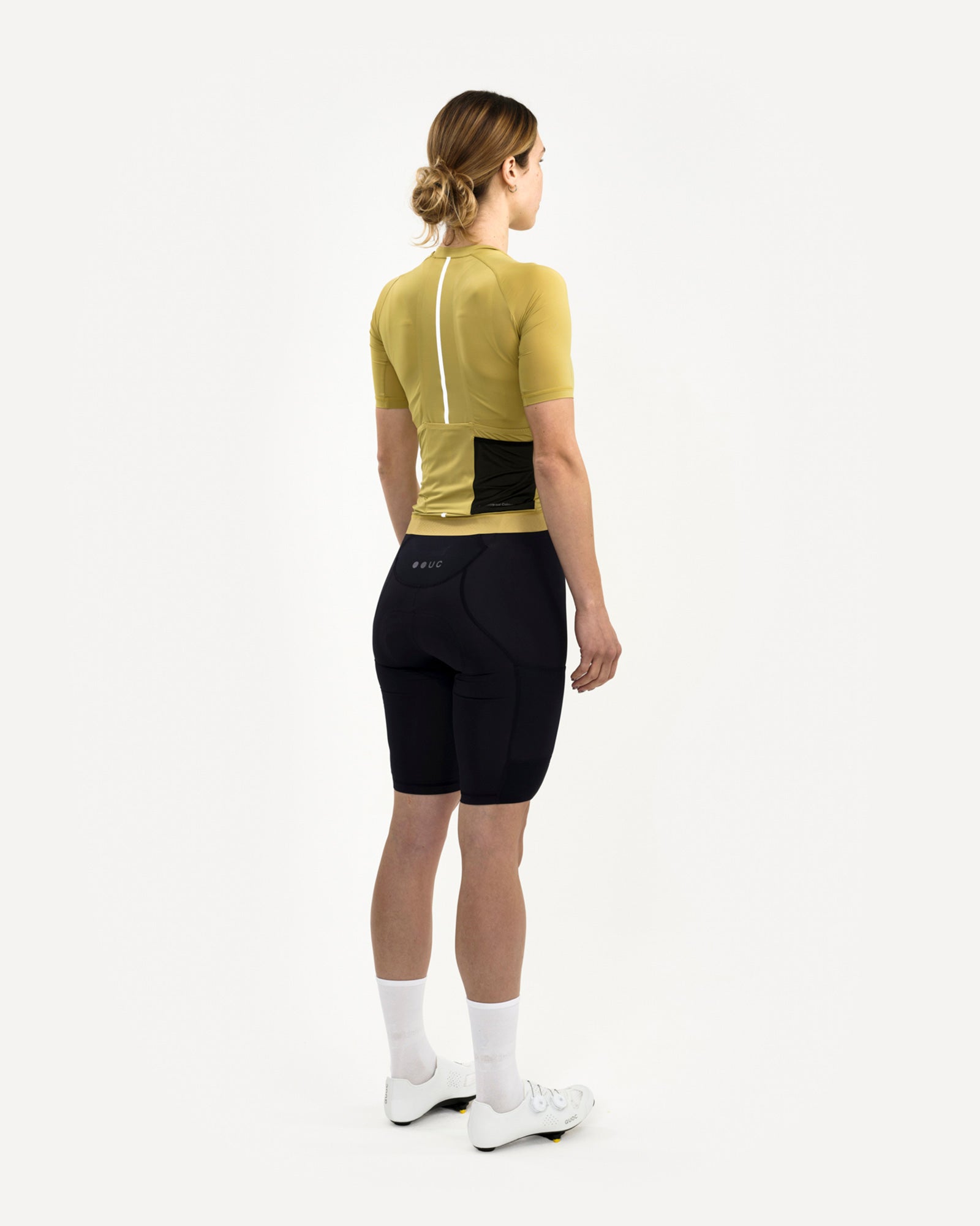 Back three-quarter of the Acidic Yellow Mono Short Sleeve Jersey: mesh side panels, dropped tail hem, paired with black bibs.
