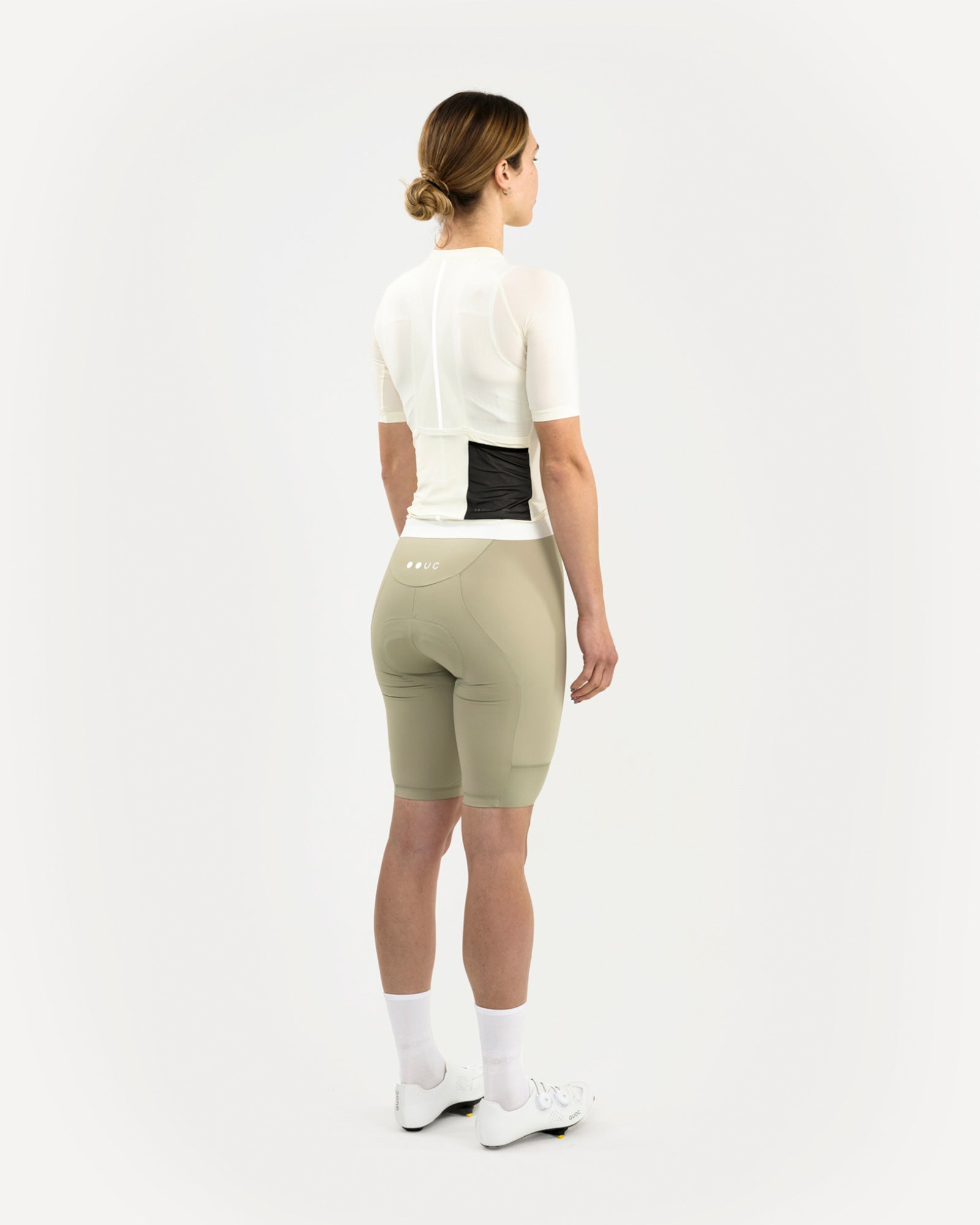Women's Mono jersey in Tampered White styled with sage bib shorts and white road shoes, back three-quarter view.