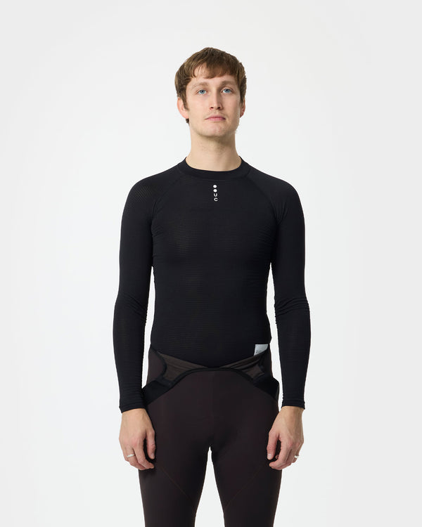 Model wearing the Men's Thermal Base Layer in Black under an aubergine mesh bib short, front view.