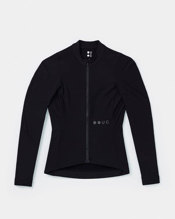 Flatlay: Women's Mono Long Sleeve Jersey in Black, high mock collar, full-length zip, tonal UC dot mark and gripper tail hem.