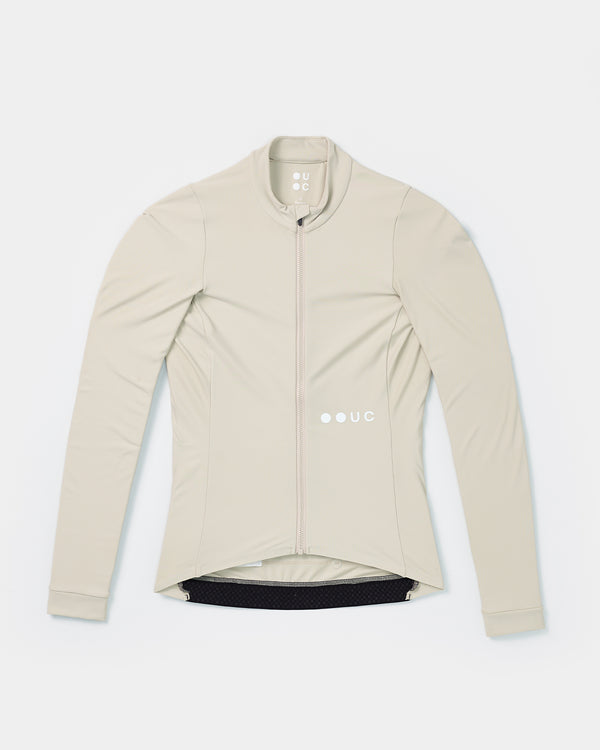 Flatlay of the Women's Mono Long Sleeve Jersey in Stone White: full-length front zip, high collar and UC chest logo.