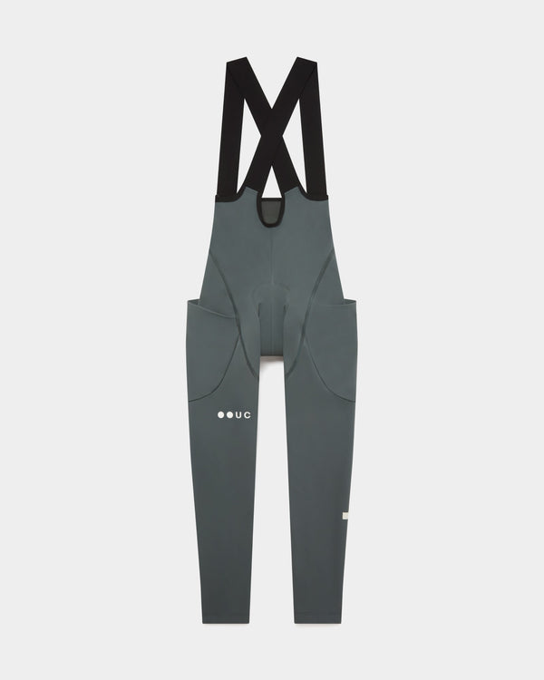 Flatlay front view: Women's Mono Cargo Bib Tight in Industrial Teal, black crossover straps and dual thigh cargo pockets.