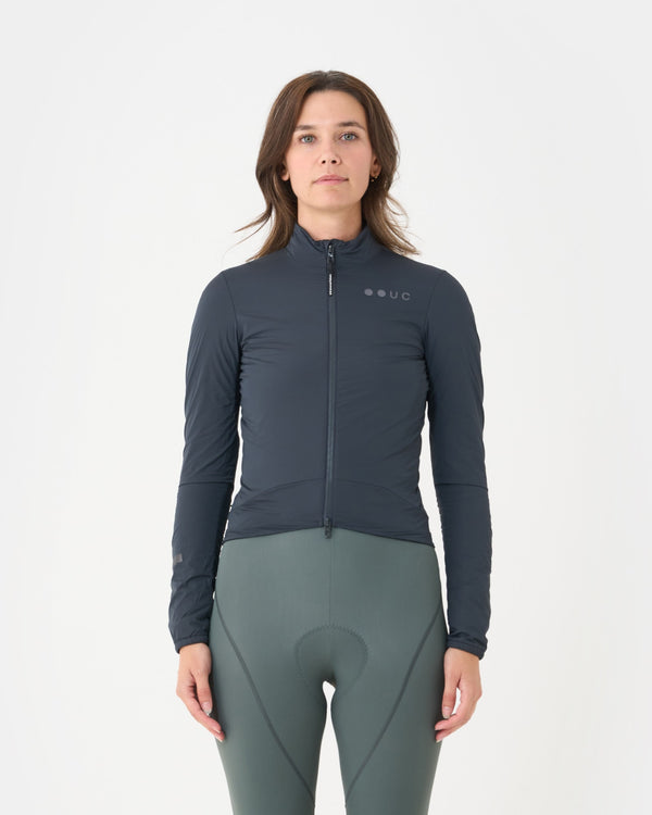 Model wearing the Women's Mono Insulated Jacket in Slate Grey, front view, paired with sage green cycling bib tights.