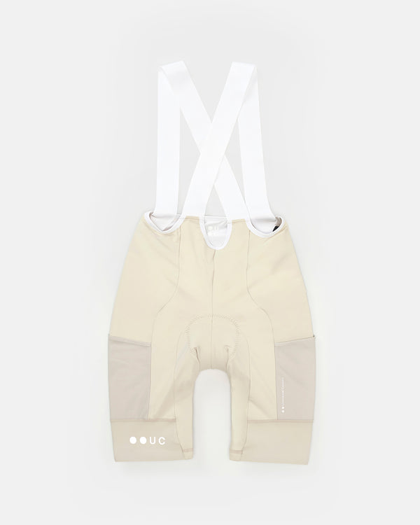 Women's Mono Cargo Bib Short in Off White, flatlay back view, white crossover straps and tonal mesh side cargo panels.