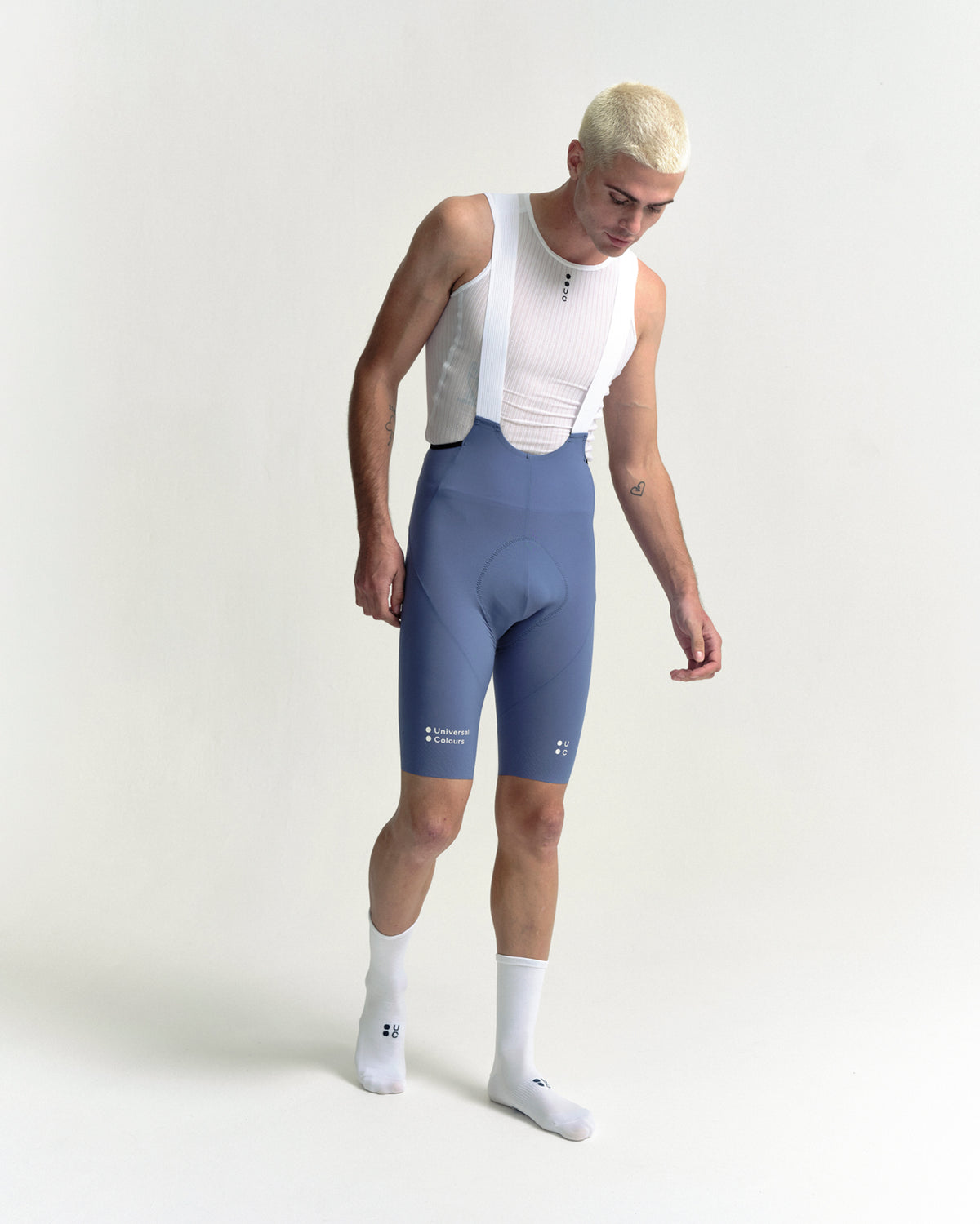 Model walking in the Men's Chroma Bib Shorts in Slate Blue, full-length view.