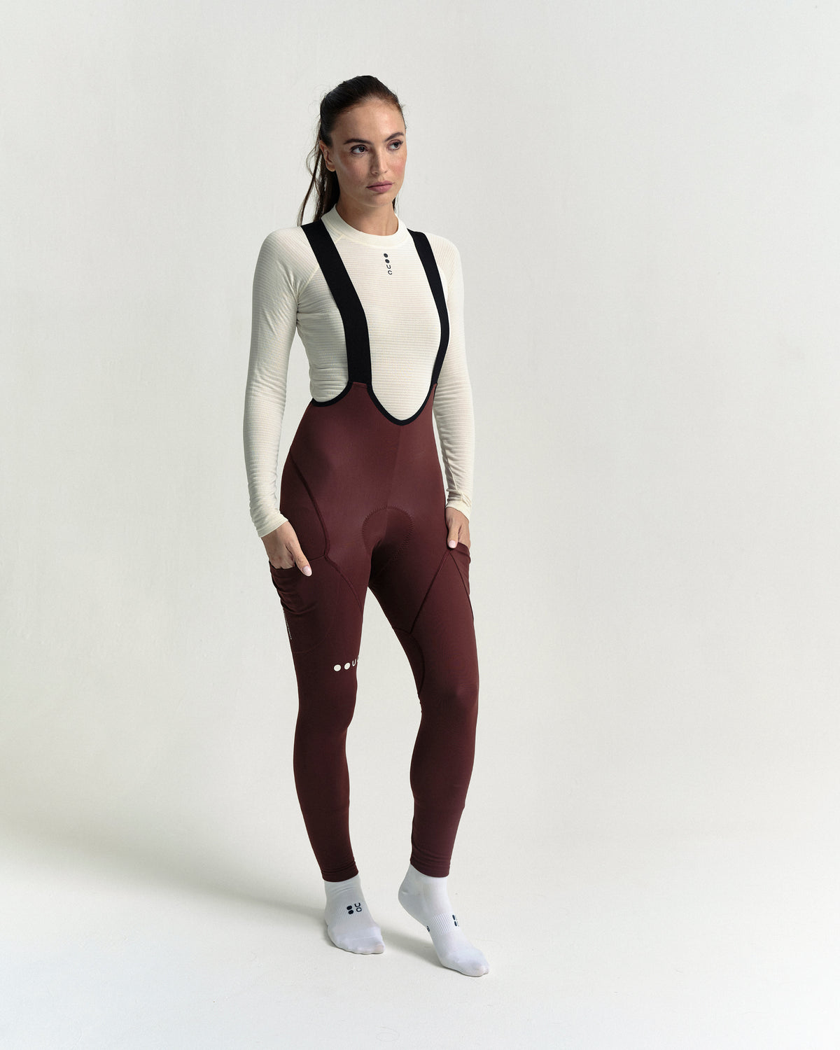 Model wearing the Women's Mono Cargo Bib Tight in Deep Red.