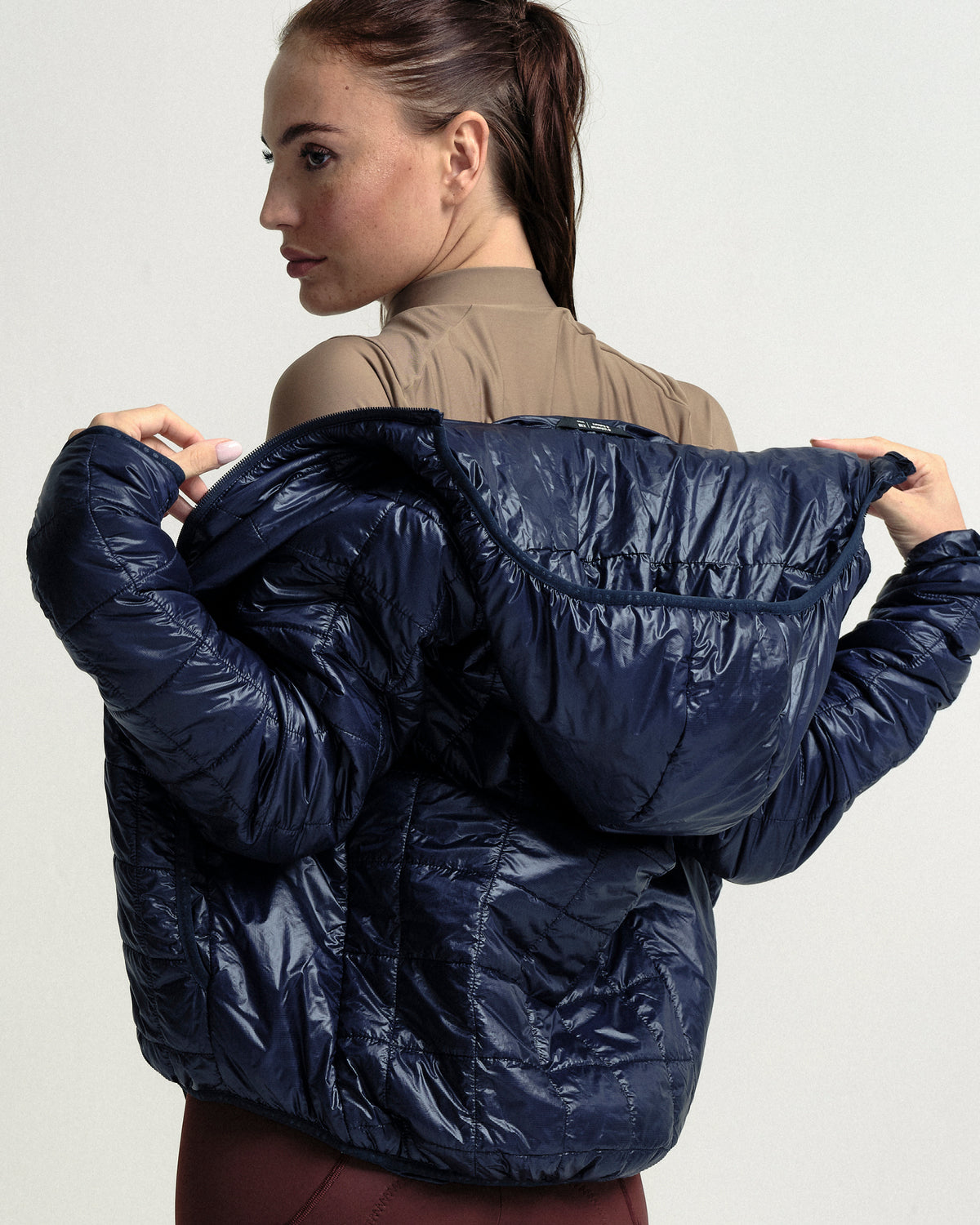 Model wearing the Unisex Insulated Packable Jacket in Ink Blue.