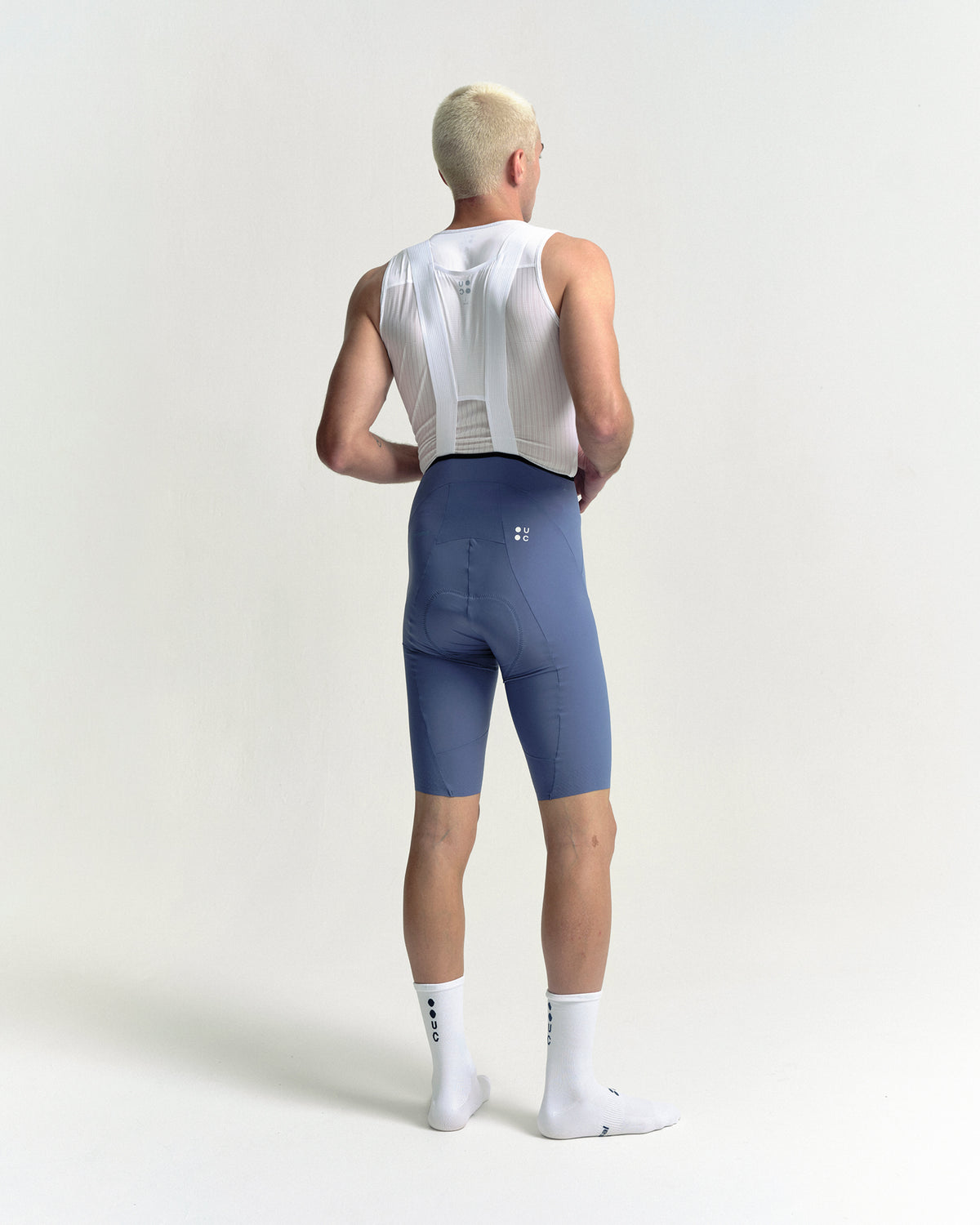 Model in the Men's Chroma Bib Shorts in Slate Blue, full-length back view.