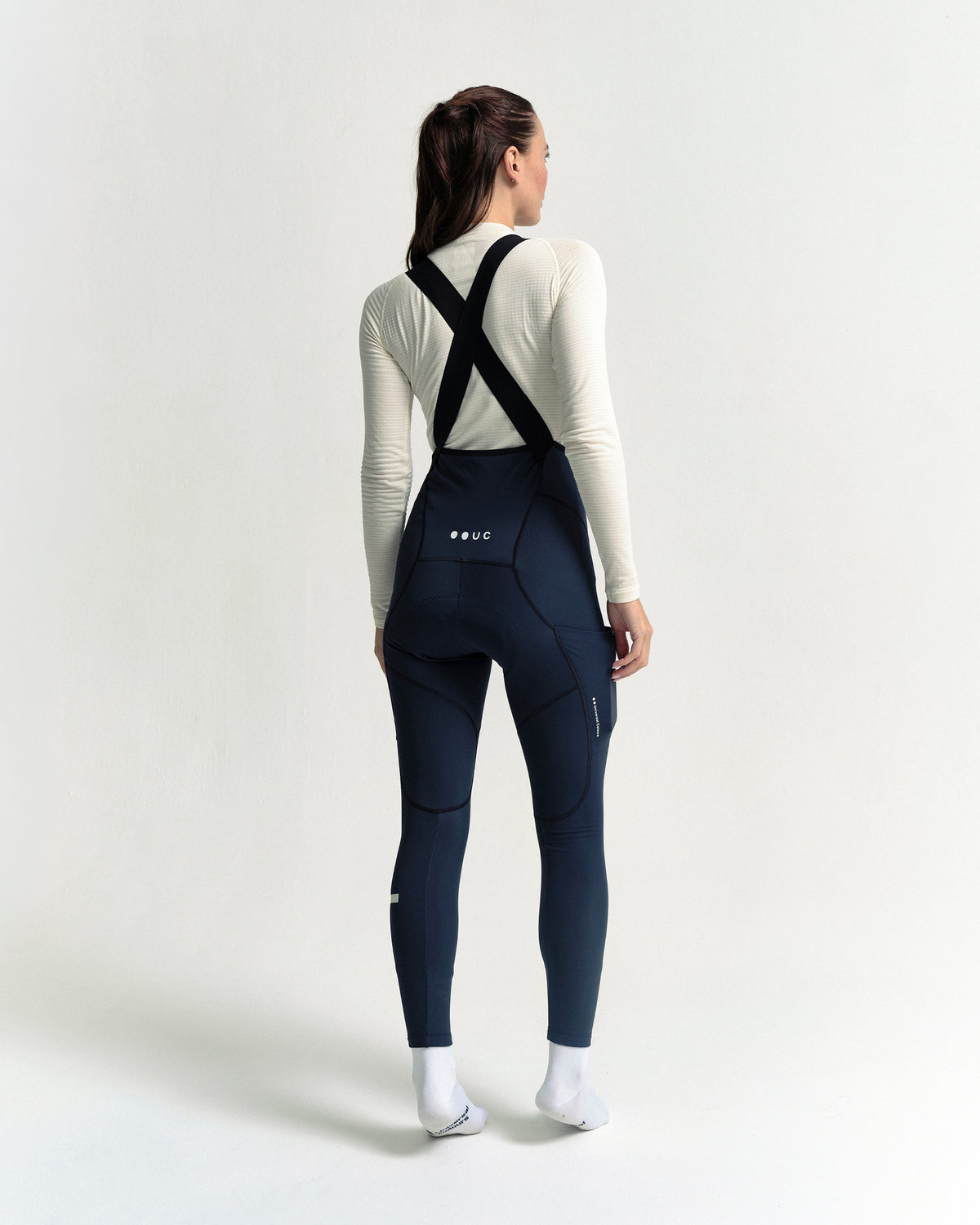 Model wearing the Women's Mono Cargo Bib Tight in Eclipse Navy.
