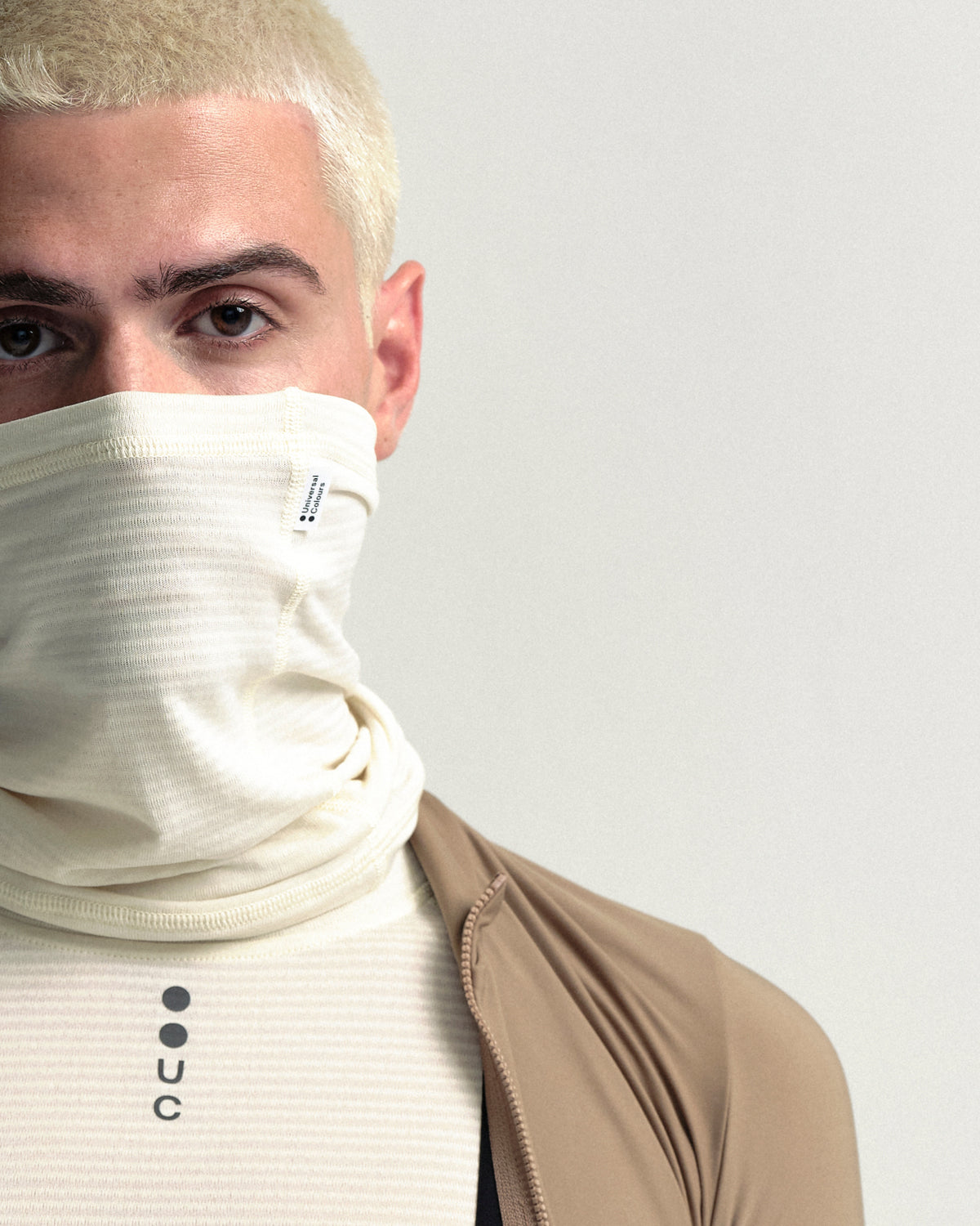 Model wearing the Polartec Neck Warmer in Off White.