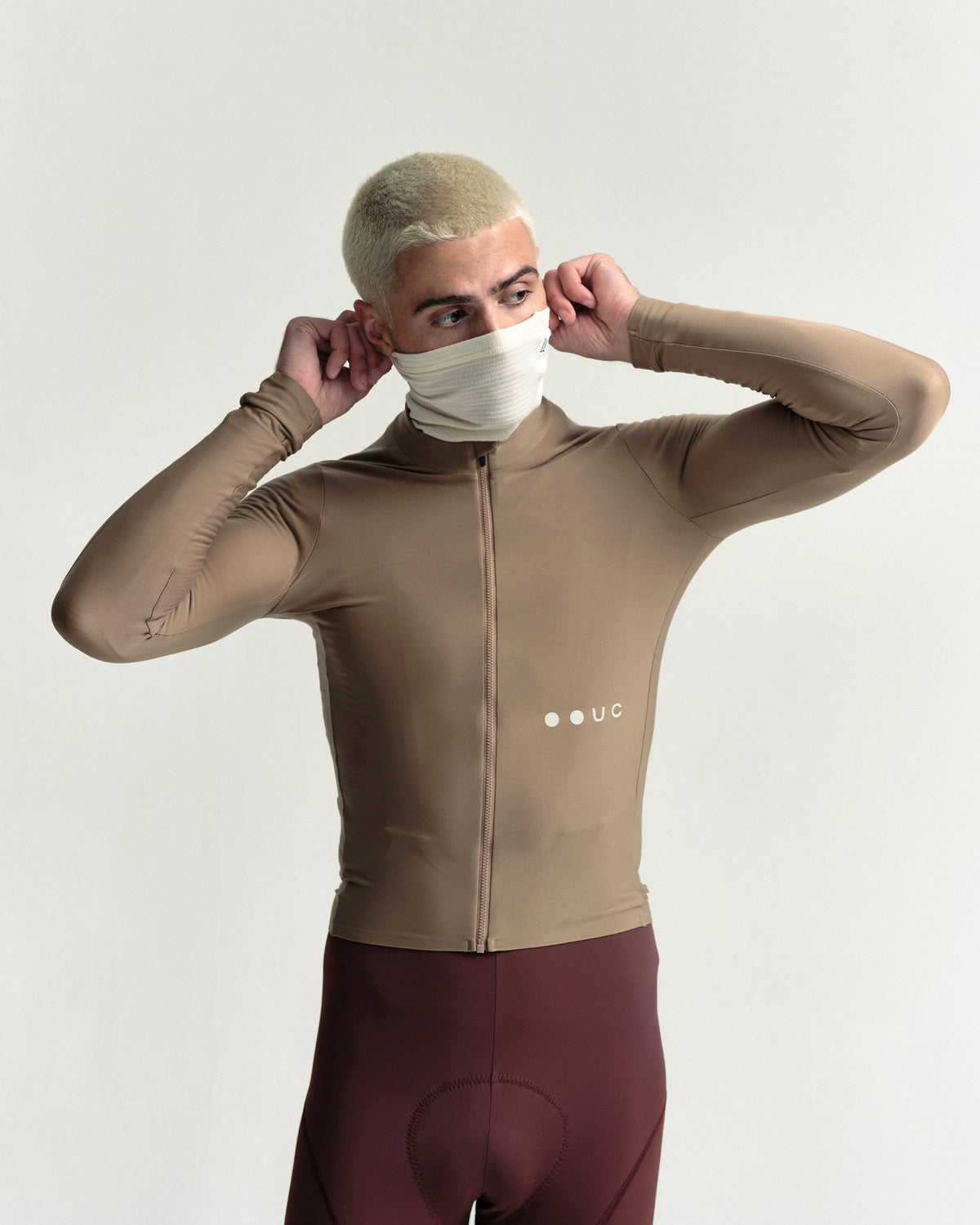 Model wearing the Polartec Neck Warmer in Off White.