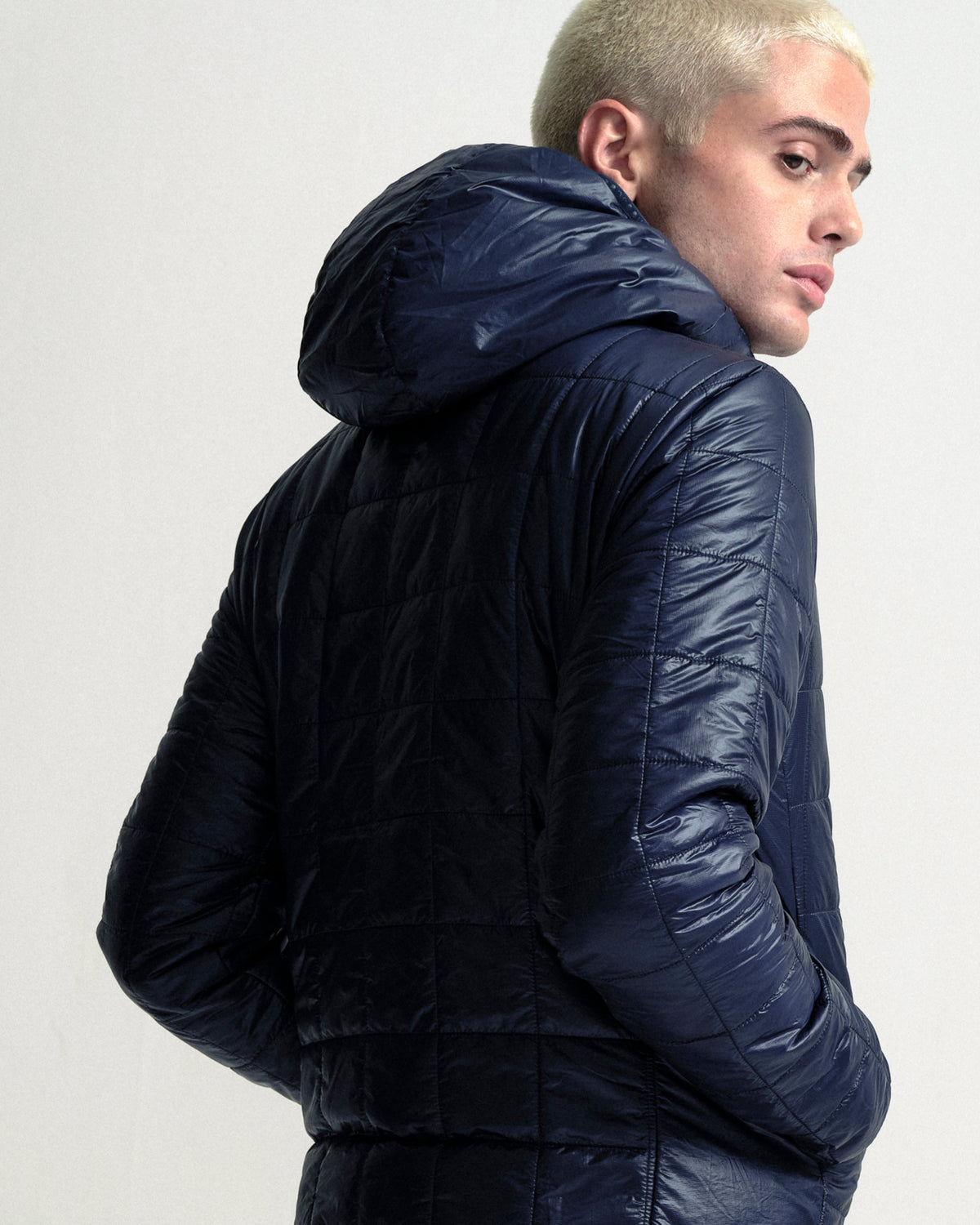 Model wearing the Unisex Insulated Packable Jacket in Ink Blue.